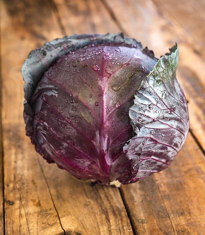 Red cabbage isolated on wooden background